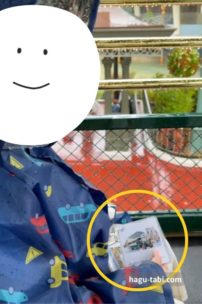 雨の日のディズニーで絵カードを首から下げて確認するASDの子ども